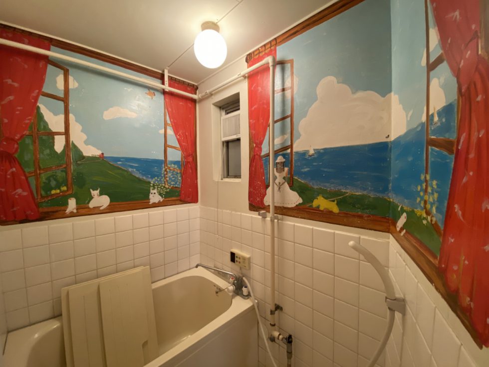 シャワールームには独特な絵が。ここにもあしらわれる「赤い」カーテンは以前使われていた人の好みを感じられます。