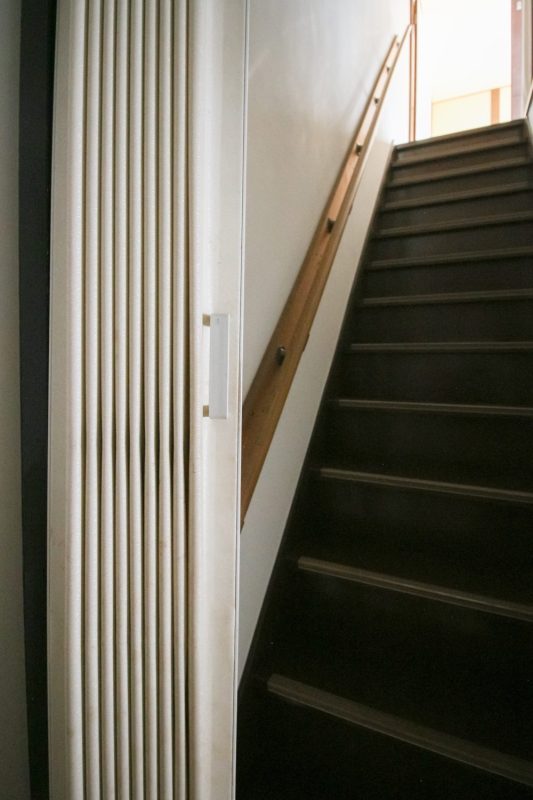 階段の前にはアコーディオンカーテンが。店舗部分と住居部分を分けられる
